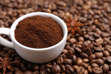 Photo of Cup with instant coffee powder and star anise on beans, closeup