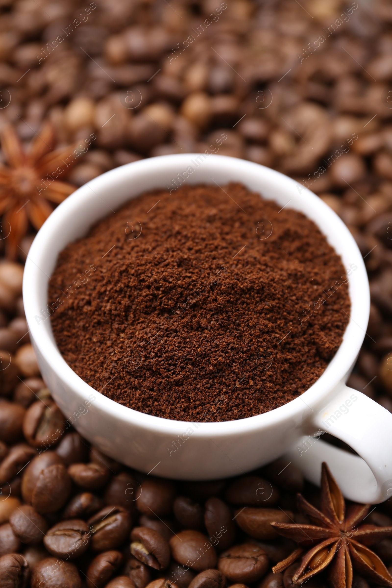 Cup with instant coffee powder and star anise on beans, closeup Photo of Cup with instant coffee powder and star anise on beans, closeup