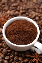 Photo of Cup with instant coffee powder and star anise on beans, closeup