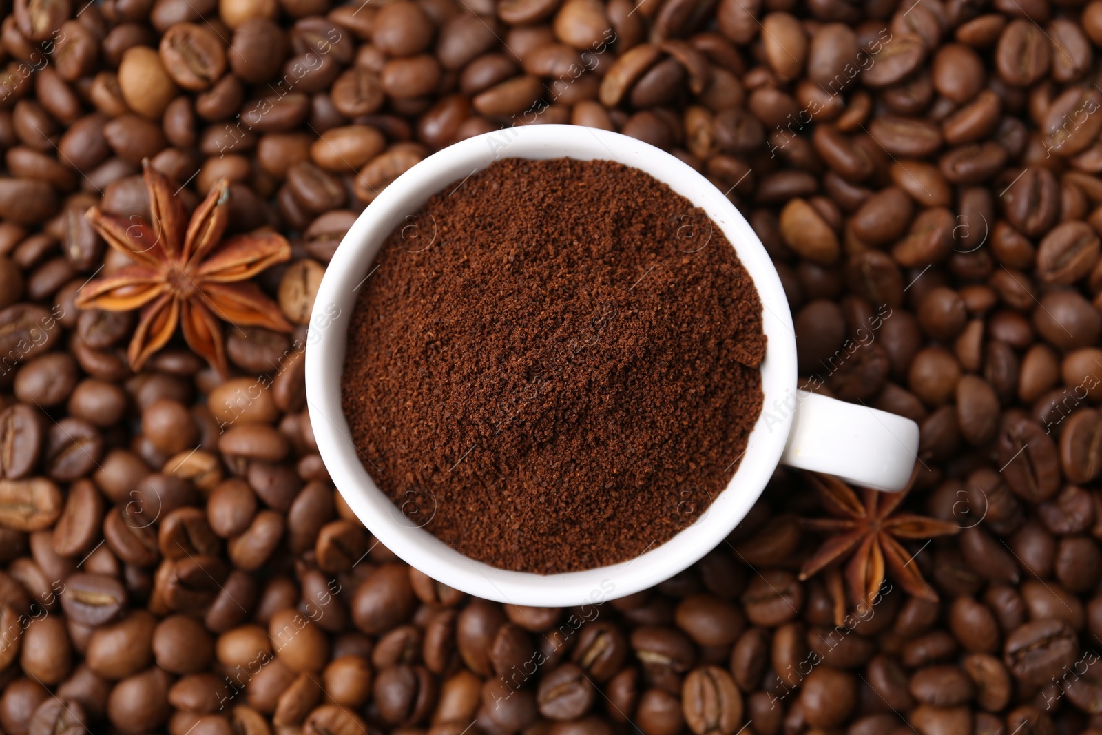 Cup with instant coffee powder and star anise on beans, top view Photo of Cup with instant coffee powder and star anise on beans, top view