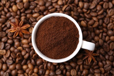 Photo of Cup with instant coffee powder and star anise on beans, top view