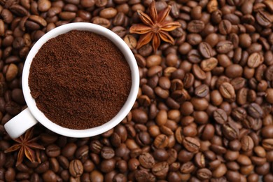 Photo of Cup with instant coffee powder and star anise on beans, top view. Space for text