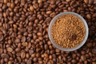 Photo of Glass jar with granulated instant coffee on beans, top view. Space for text