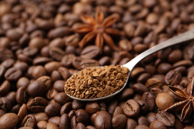 Photo of Spoon with granulated instant coffee and star anise on beans, closeup