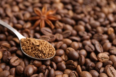 Photo of Spoon with granulated instant coffee and star anise on beans, closeup. Space for text