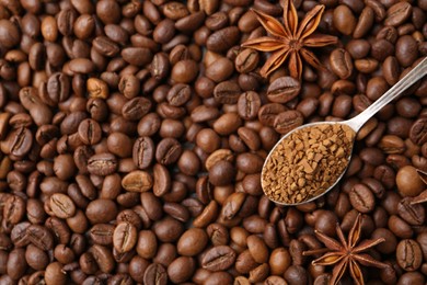 Photo of Spoon with granulated instant coffee and star anise on beans, top view. Space for text