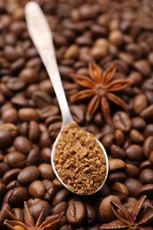 Photo of Spoon with granulated instant coffee and star anise on beans, closeup