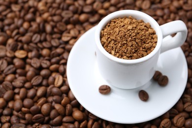 Photo of Cup with granulated instant coffee on beans, closeup. Space for text