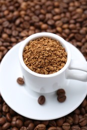 Photo of Cup with granulated instant coffee on beans, closeup