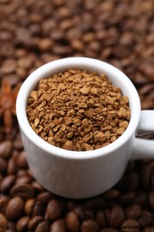 Photo of Cup with granulated instant coffee and star anise on beans, closeup