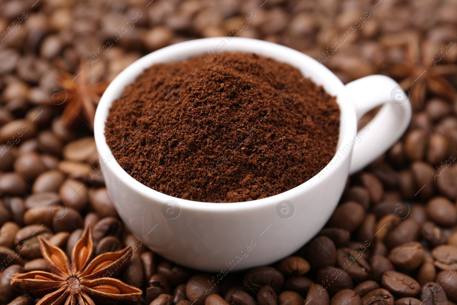 Photo of Cup with instant coffee powder and star anise on beans, closeup