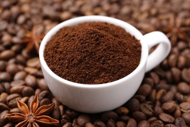 Photo of Cup with instant coffee powder and star anise on beans, closeup