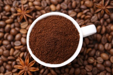 Photo of Cup with instant coffee powder and star anise on beans, top view