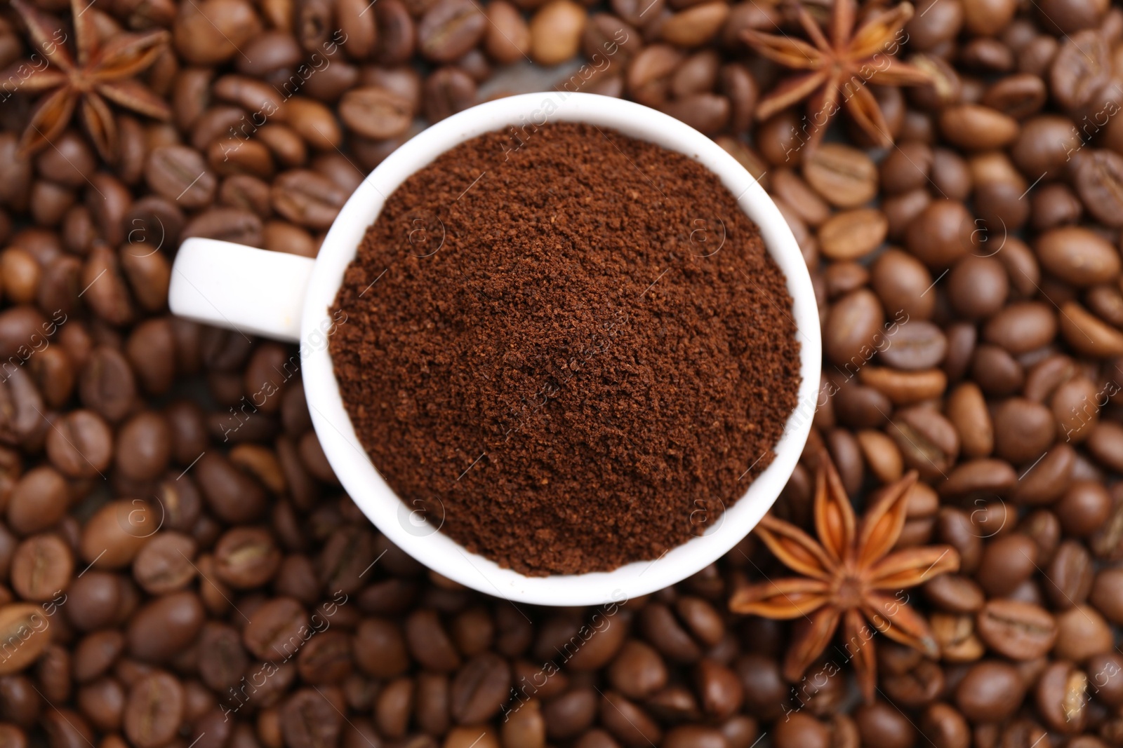 Cup with instant coffee powder and star anise on beans, top view Photo of Cup with instant coffee powder and star anise on beans, top view