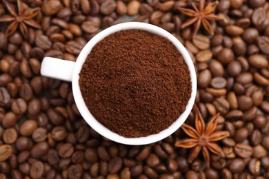 Photo of Cup with instant coffee powder and star anise on beans, top view