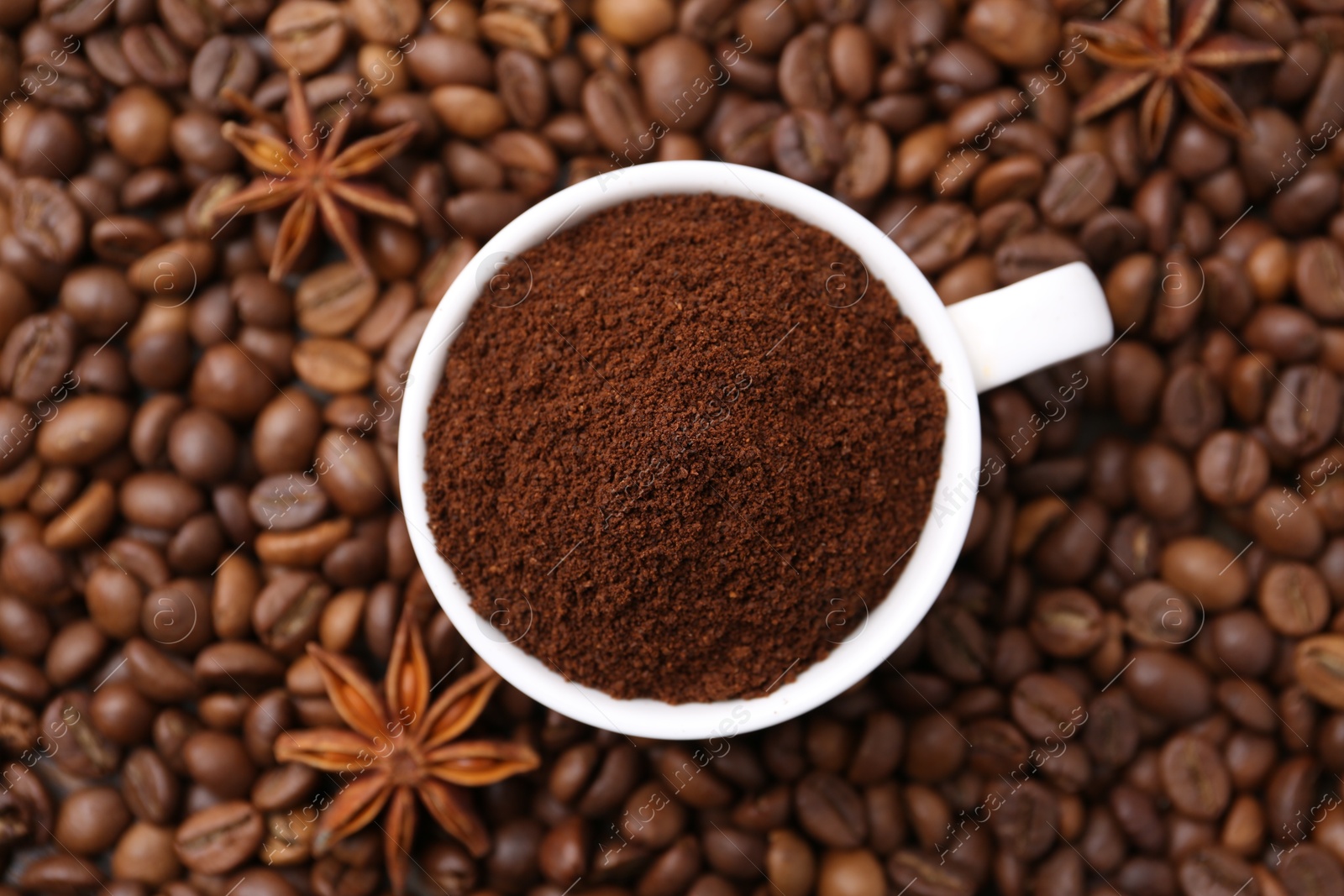 Cup with instant coffee powder and star anise on beans, top view Photo of Cup with instant coffee powder and star anise on beans, top view