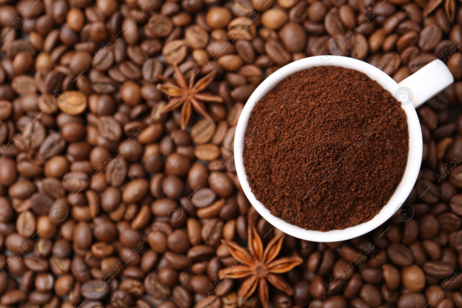 Cup with instant coffee powder and star anise on beans, top view. Space for text Photo of Cup with instant coffee powder and star anise on beans, top view. Space for text