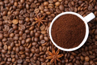 Photo of Cup with instant coffee powder and star anise on beans, top view. Space for text