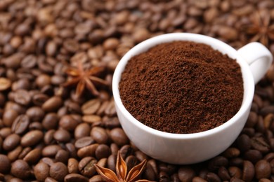 Photo of Cup with instant coffee powder and star anise on beans, closeup. Space for text