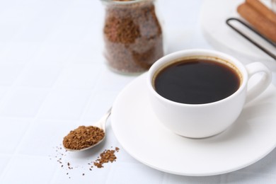 Photo of Cup of aromatic coffee and granulated instant coffee on white table, closeup. Space for text