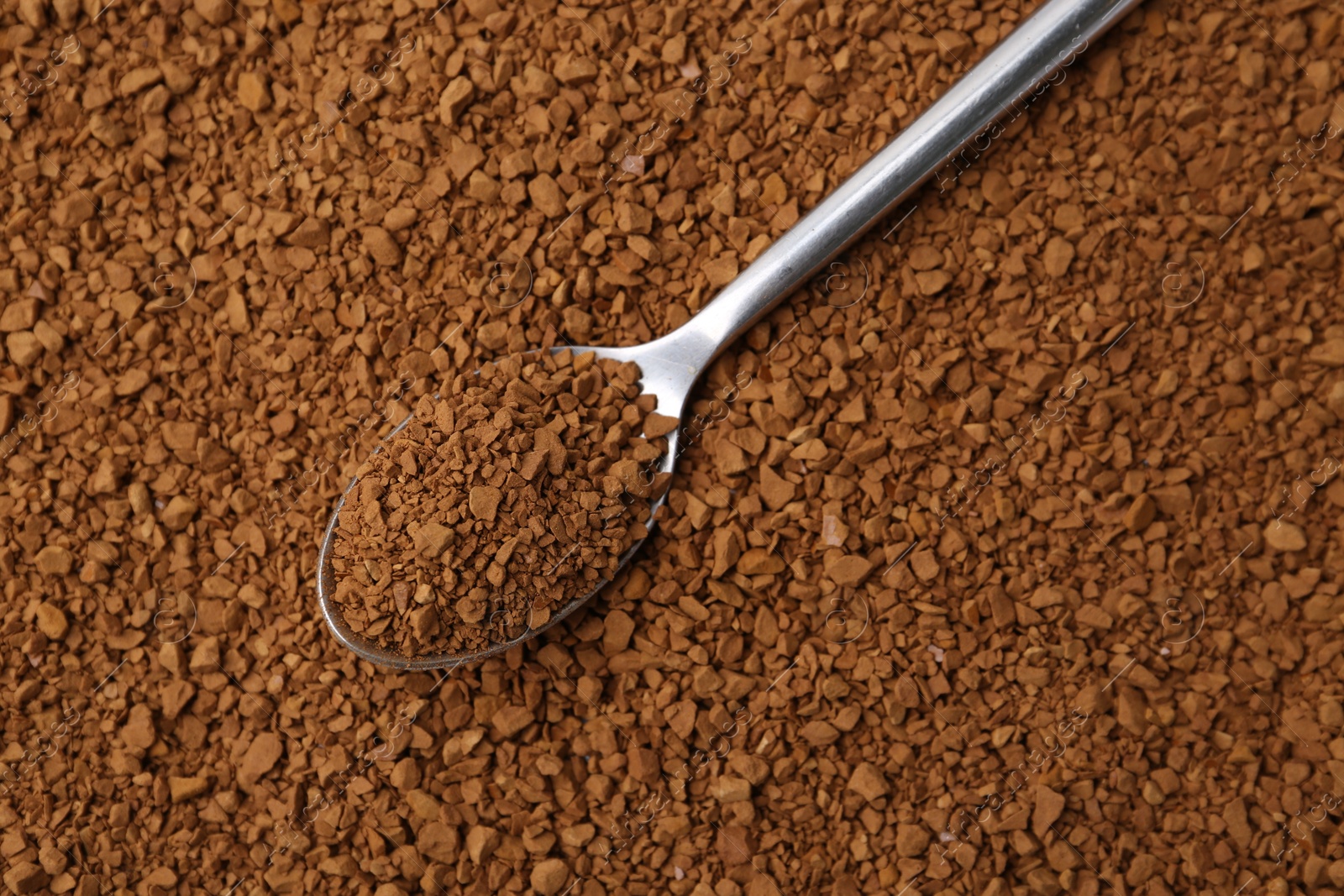 Spoon on aromatic granulated instant coffee, top view Photo of Spoon on aromatic granulated instant coffee, top view