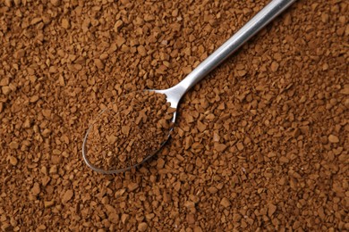 Photo of Spoon on aromatic granulated instant coffee, top view