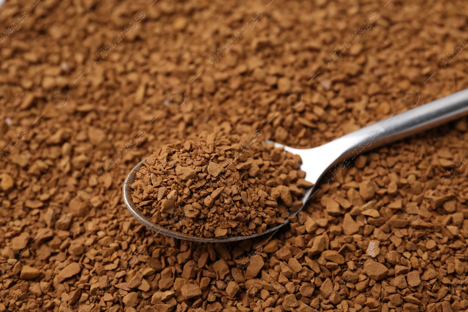 Spoon on aromatic granulated instant coffee, closeup view Photo of Spoon on aromatic granulated instant coffee, closeup view
