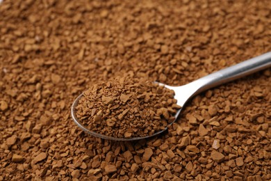 Photo of Spoon on aromatic granulated instant coffee, closeup view