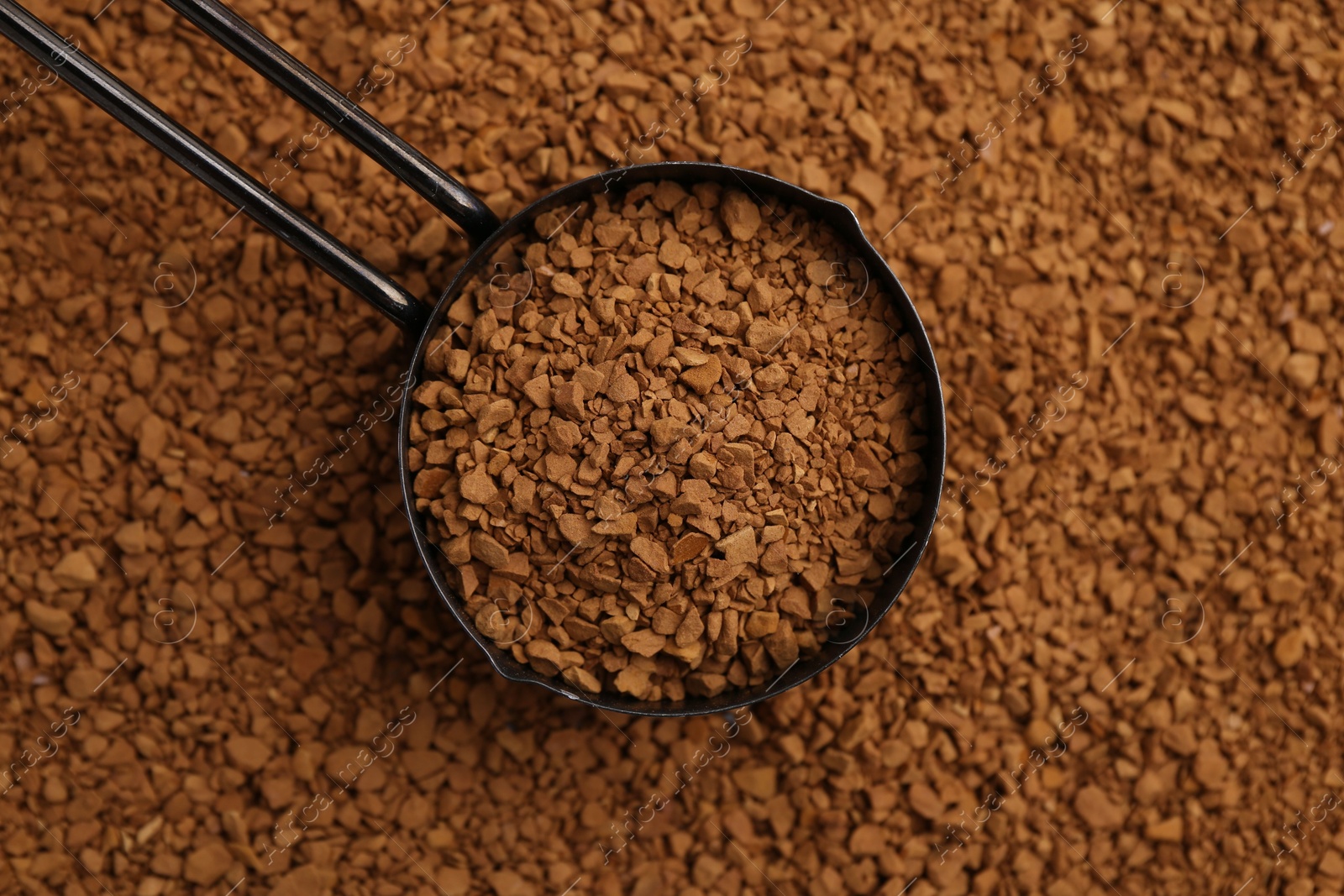 Scoop on aromatic granulated instant coffee, top view Photo of Scoop on aromatic granulated instant coffee, top view