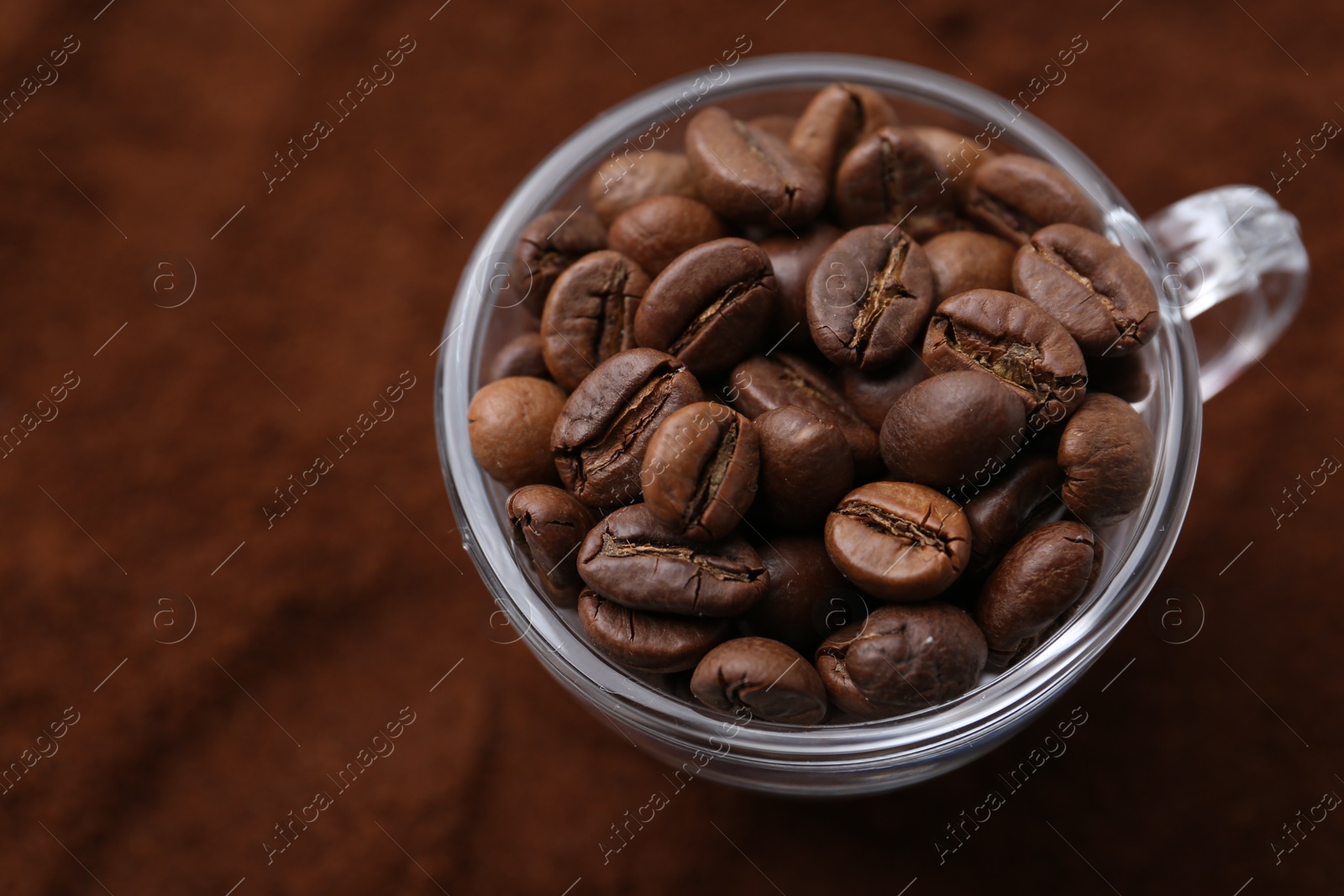 Cup of roasted coffee beans on powder, above view Photo of Cup of roasted coffee beans on powder, above view