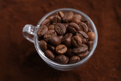 Photo of Cup of roasted coffee beans on powder, above view