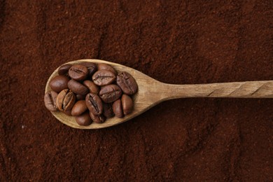 Photo of Roasted coffee beans in spoon on powder, top view