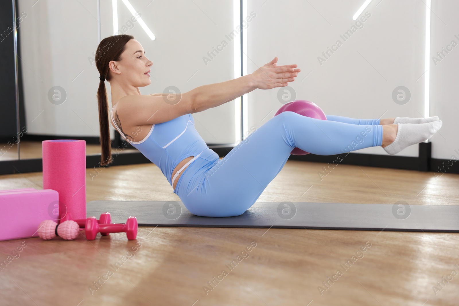 Woman exercising on mat in fitness studio Photo of Woman exercising on mat in fitness studio