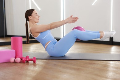 Photo of Woman exercising on mat in fitness studio