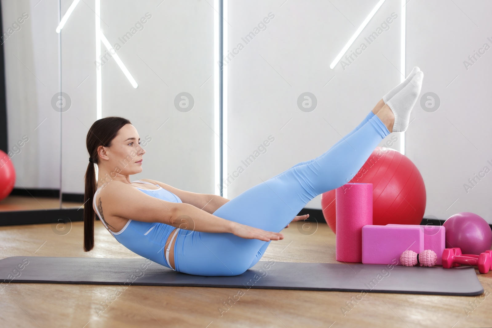 Woman exercising on mat in fitness studio Photo of Woman exercising on mat in fitness studio