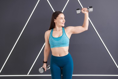 Photo of Woman exercising with dumbbells in fitness studio