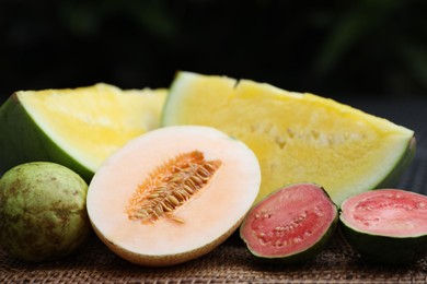 Photo of Ripe juicy tropical fruits on wicker table, closeup