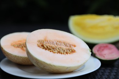 Photo of Ripe juicy tropical fruits on wicker table, closeup