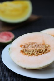 Photo of Ripe juicy tropical fruits on wicker table, closeup