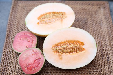 Photo of Ripe juicy tropical fruits on wicker tray, closeup