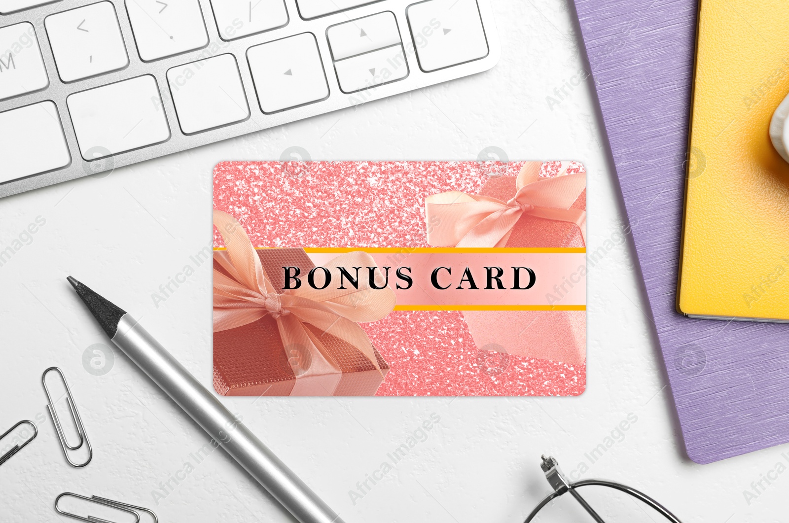 Bonus card with stylish design, stationery and computer keyboard on white table, flat lay Image of Bonus card with stylish design, stationery and computer keyboard on white table, flat lay