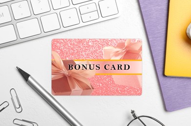Image of Bonus card with stylish design, stationery and computer keyboard on white table, flat lay