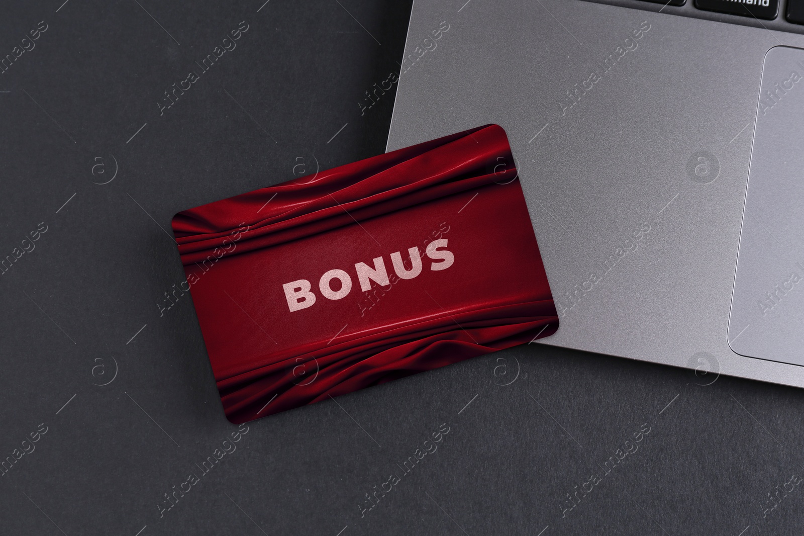 Bonus card with stylish design and laptop on grey table Image of Bonus card with stylish design and laptop on grey table