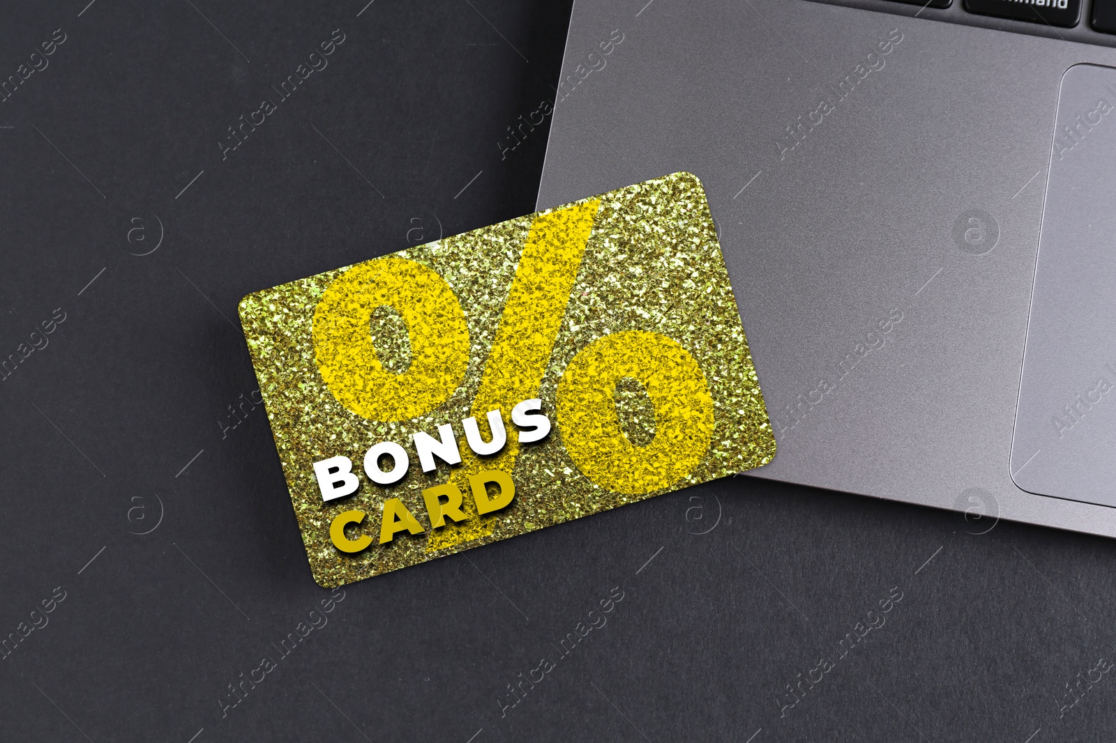 Bonus card with stylish design and laptop on grey table Image of Bonus card with stylish design and laptop on grey table