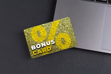 Image of Bonus card with stylish design and laptop on grey table