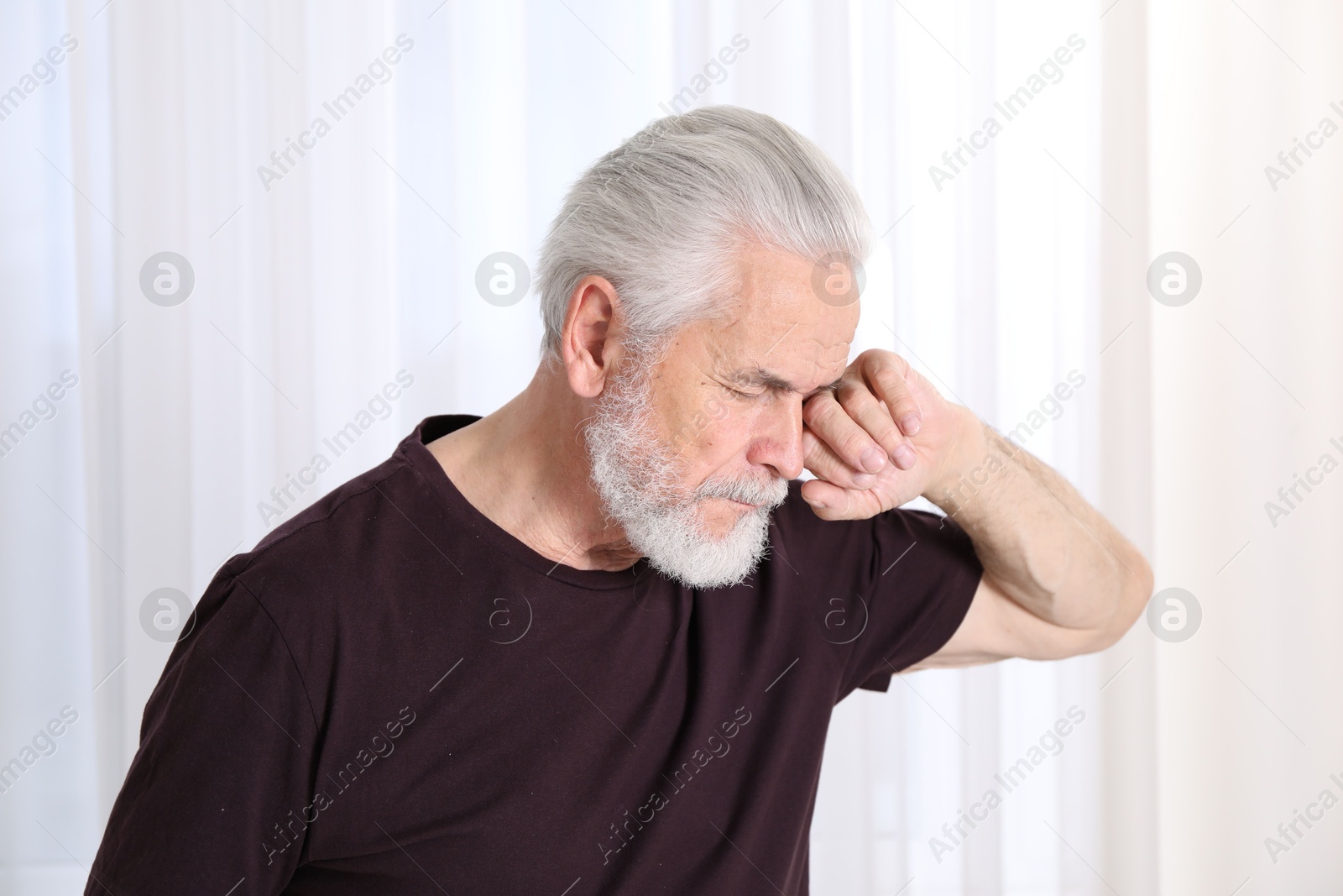 Senior man suffering from eyestrain at home Photo of Senior man suffering from eyestrain at home