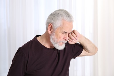 Photo of Senior man suffering from eyestrain at home