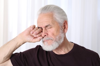 Photo of Senior man suffering from eyestrain at home