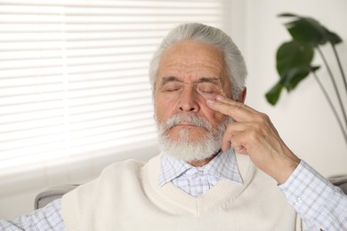 Photo of Senior man suffering from eyestrain at home