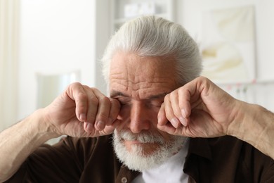 Photo of Senior man suffering from eyestrain at home